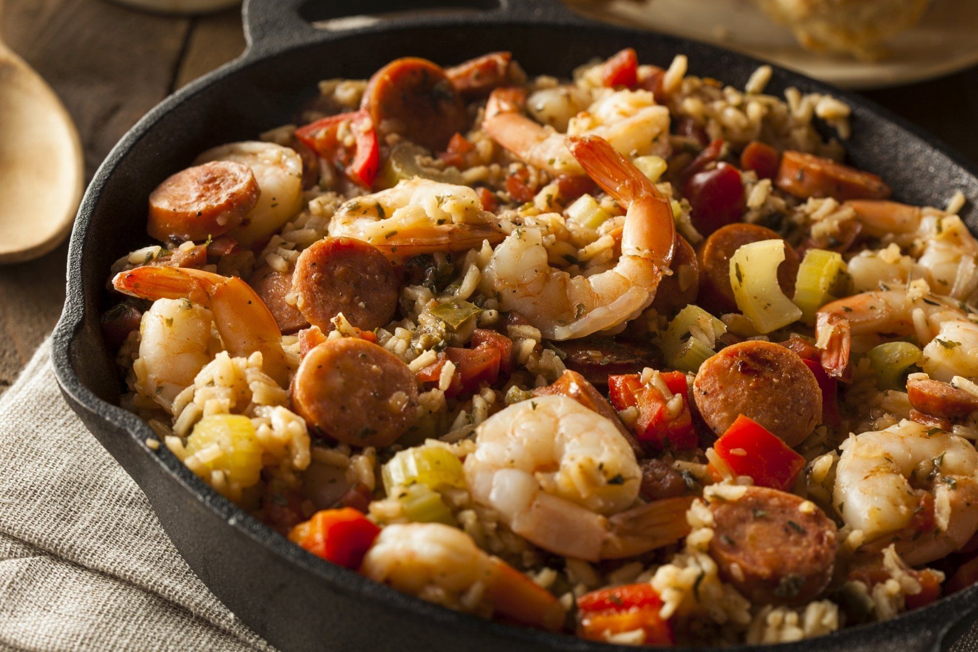 Jambalaya met garnalen en worst in een gietijzeren koekenpan.