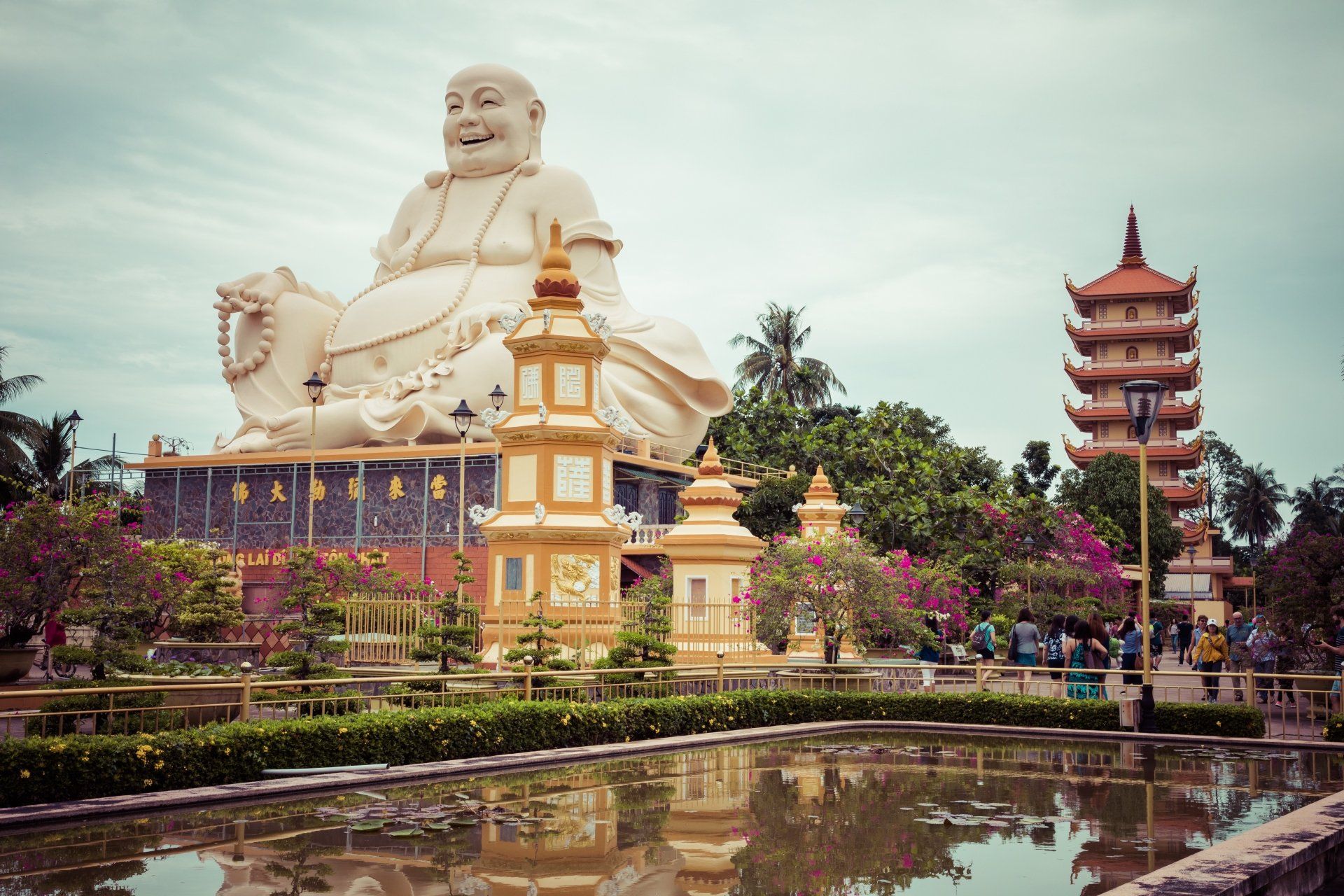 Groot wit Boeddhabeeld, pagode en vijver op een tempelcomplex.