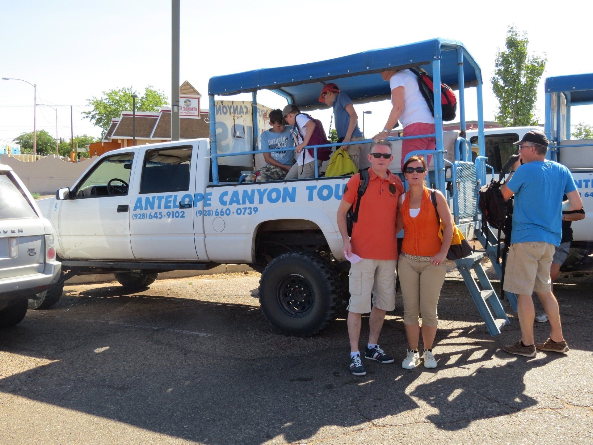Mensen poseren bij de vrachtwagen van Antelope Canyon Tours met passagiers.