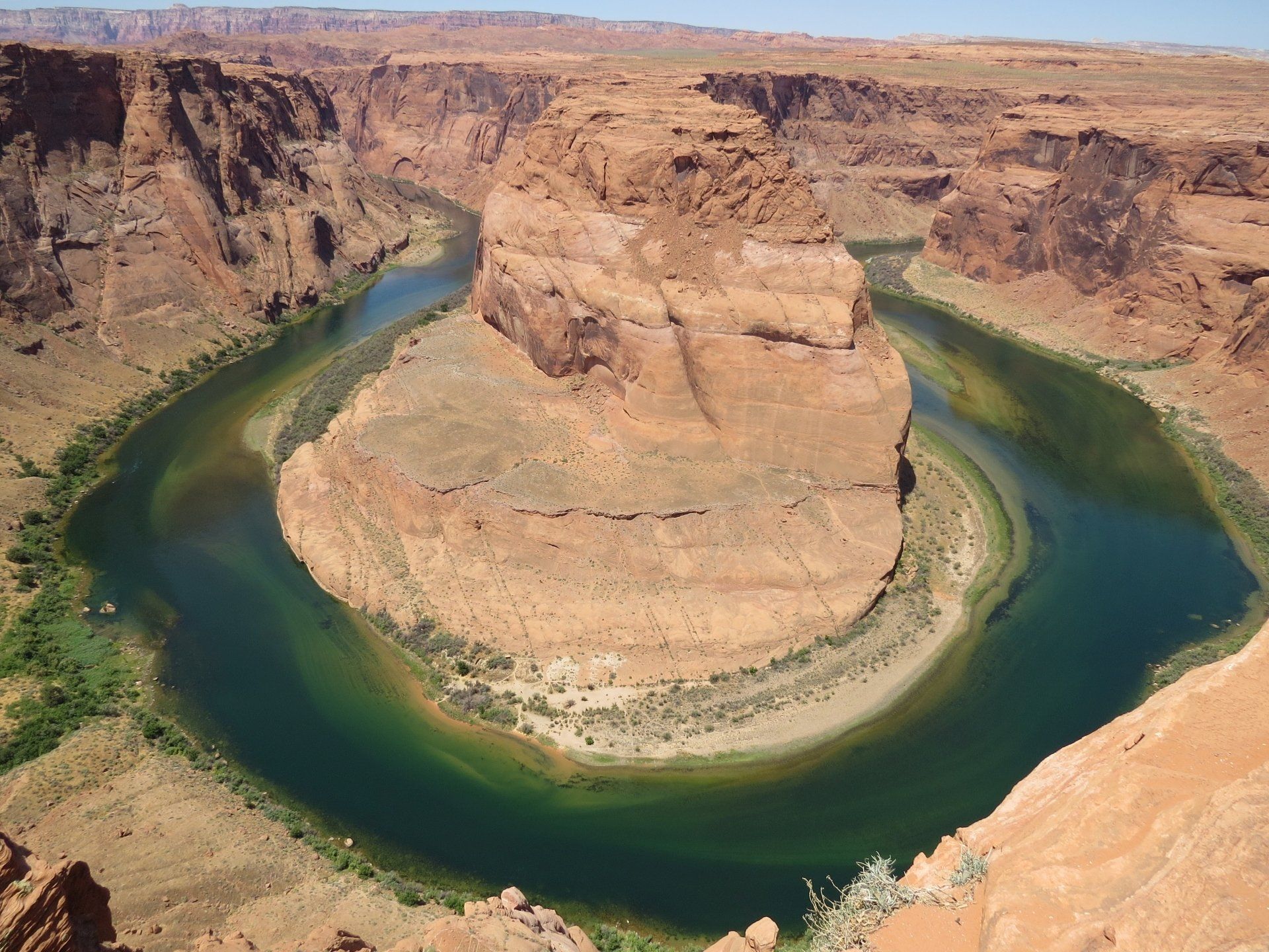 Horseshoe Bend in Arizona, een U-vormige meander in de Colorado-rivier, met roodbruine kliffen en groenblauw water.