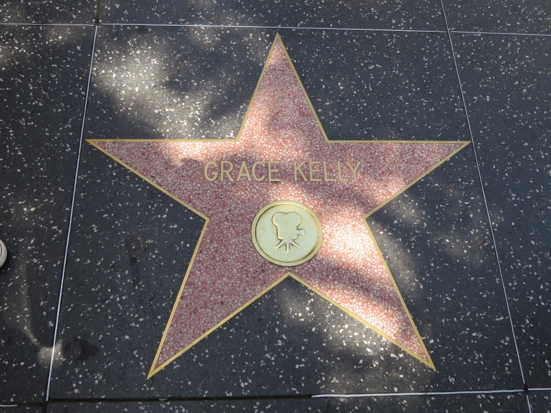 De ster van Grace Kelly op de Hollywood Walk of Fame, op een zwart trottoir. Roodbruine ster met gouden rand.