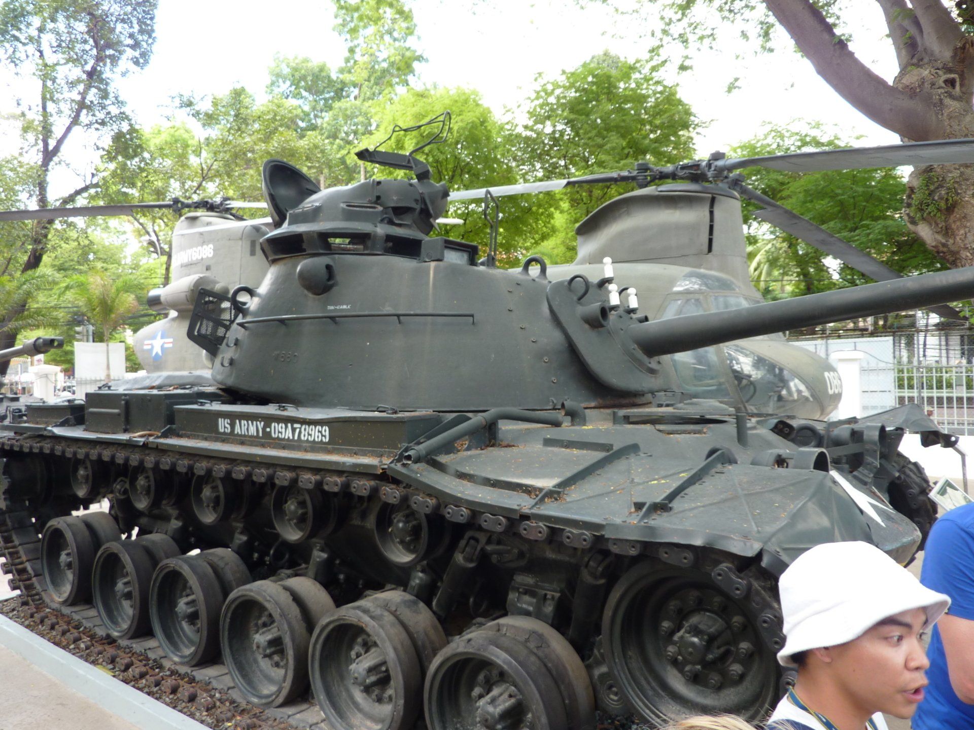 Donkergroene M41 Walker Bulldog-tank met zwarte kanonloop, naast een helikopter.