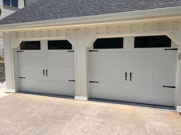 A white garage door with black handles and windows