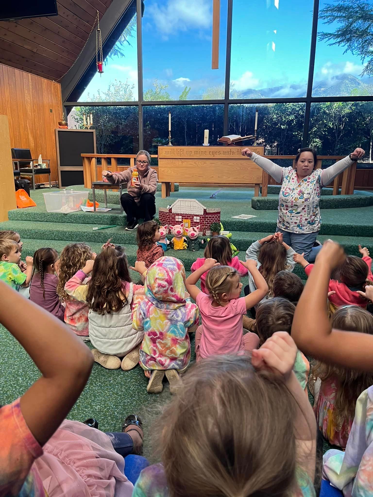 A group of children are sitting on the floor in a church.