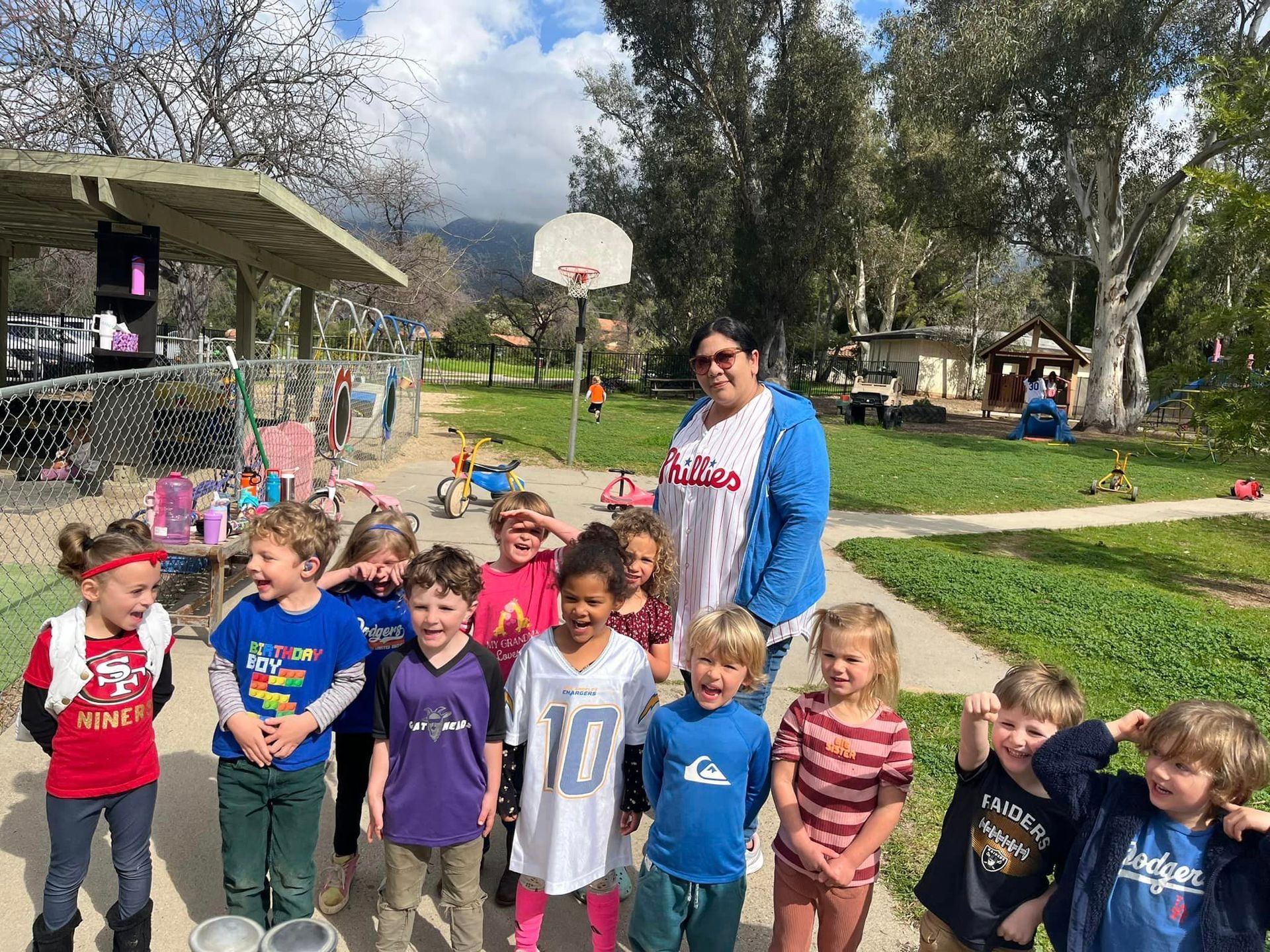 A group of children are standing next to each other in a park.