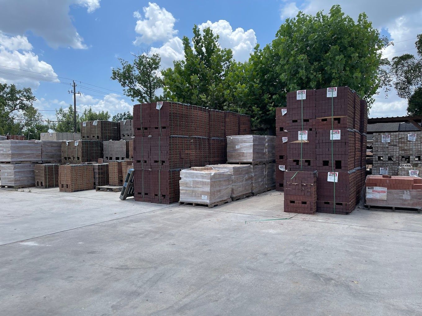 A lot of bricks are stacked on top of each other in a parking lot.