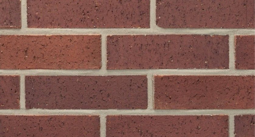 A close up of a red brick wall with a white border.