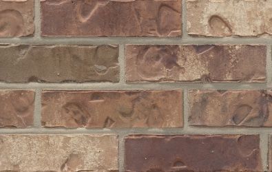 A close up of a brick wall with a few bricks missing.