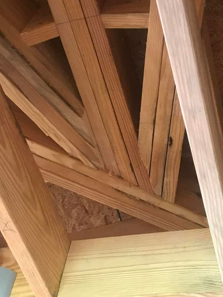 Wooden attic rafters in a triangular pattern.