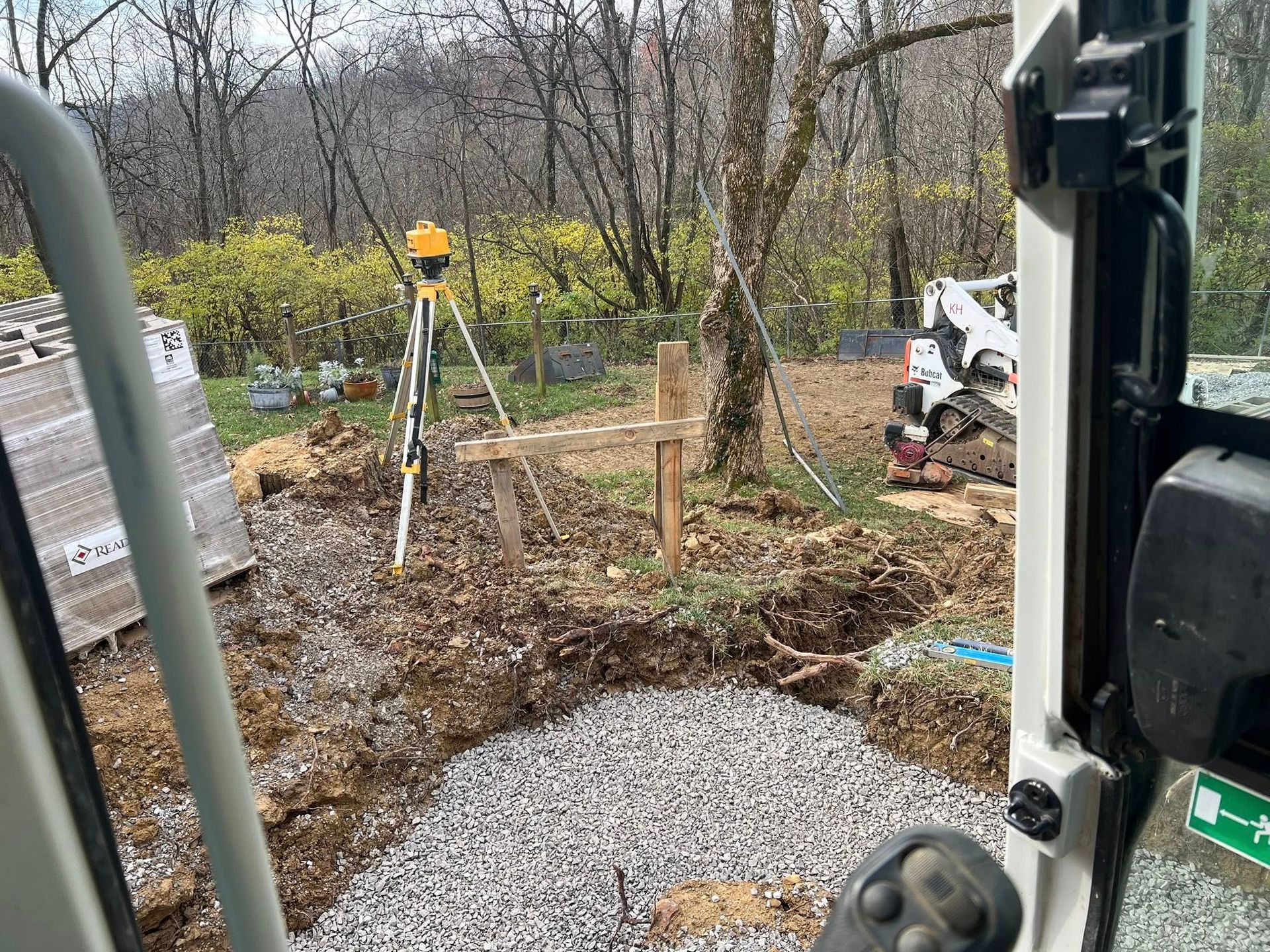 Construction site with excavator and surveying equipment.