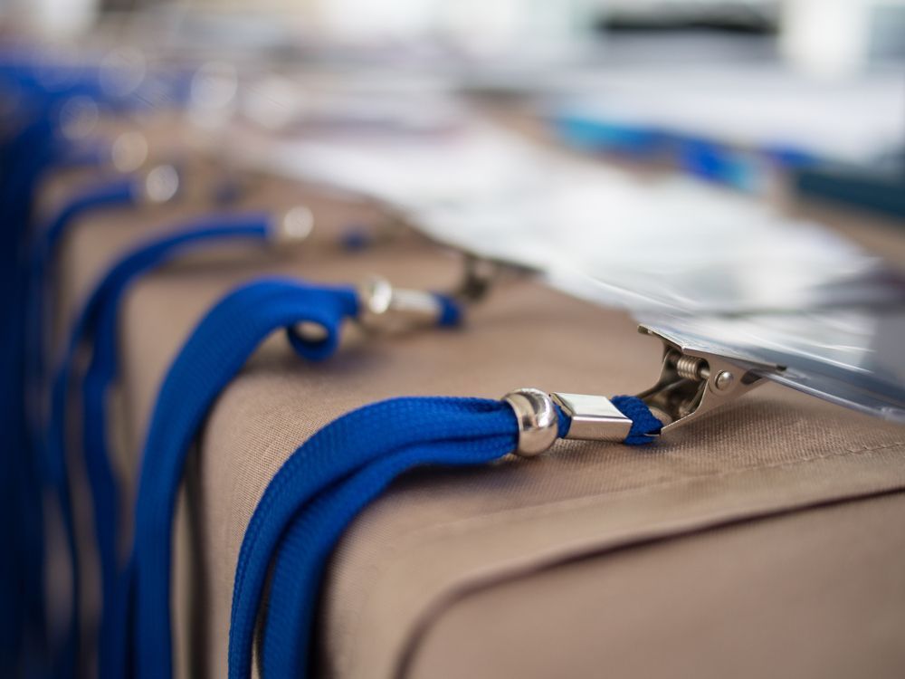 Close-up of blue and beige luggage bags with silver zippers lined up on a conveyor belt