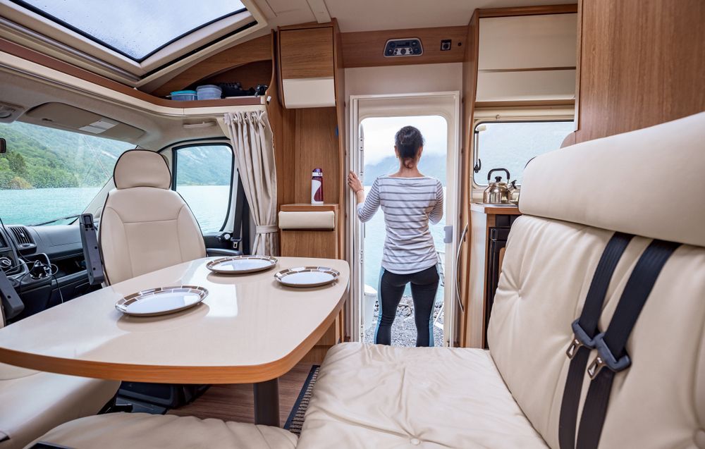 A Woman Is Standing in The Doorway of A Camper Van — Cachia Upholstery in Tuncurry, NSW