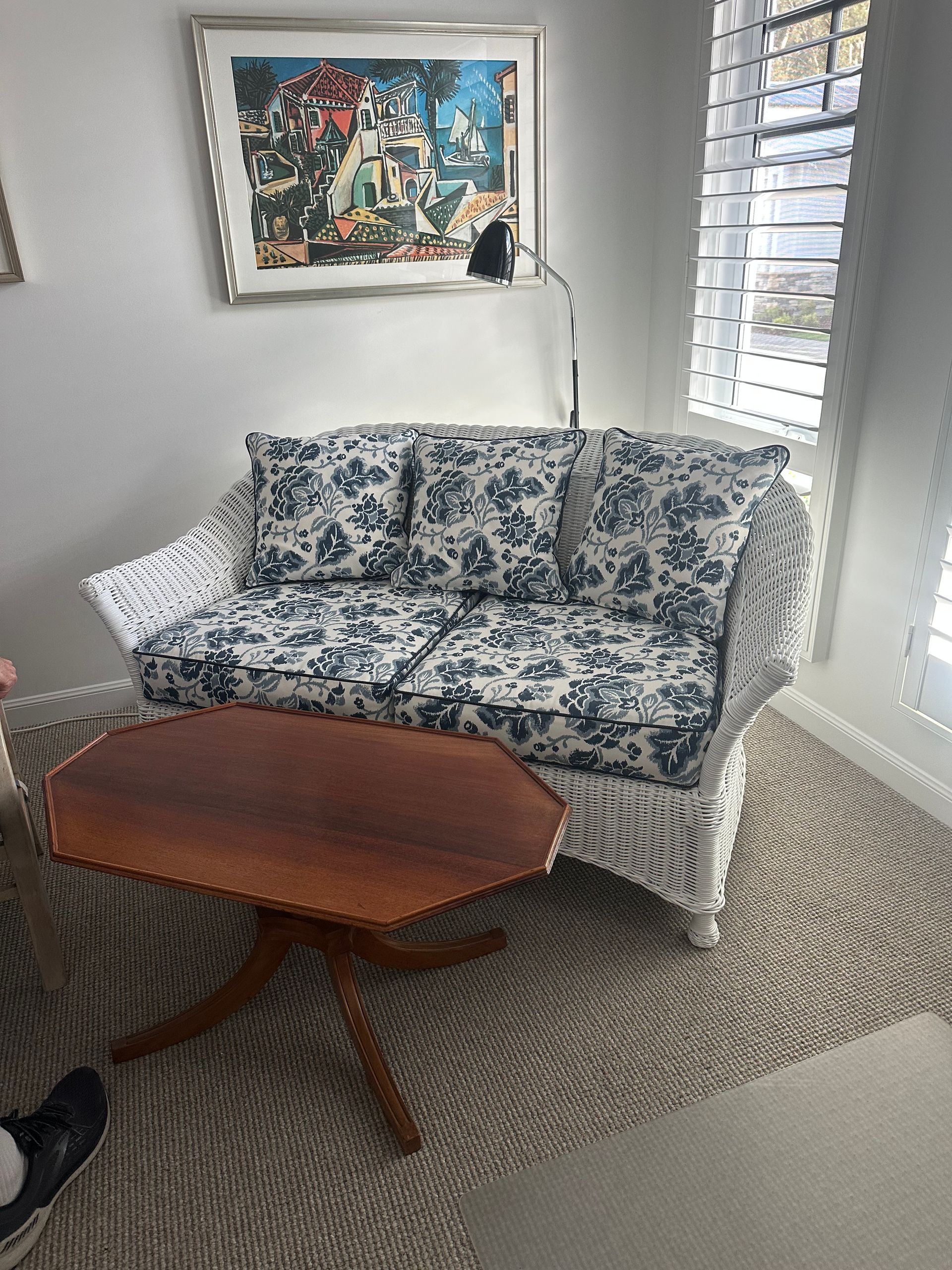 A Living Room with A Black Couch and A Vase of Flowers in Front of A Large Window — Cachia Upholstery in Nabiac, NSW