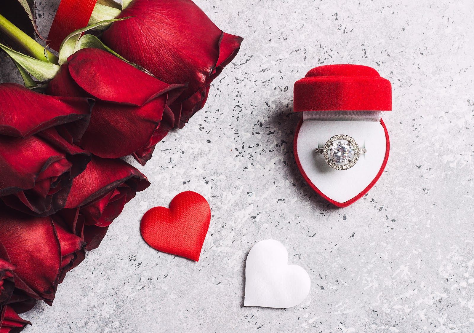 Red roses and heart-shaped boxes on a white background for a romantic gift setting
