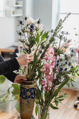 A basket filled with white flowers and pine cones