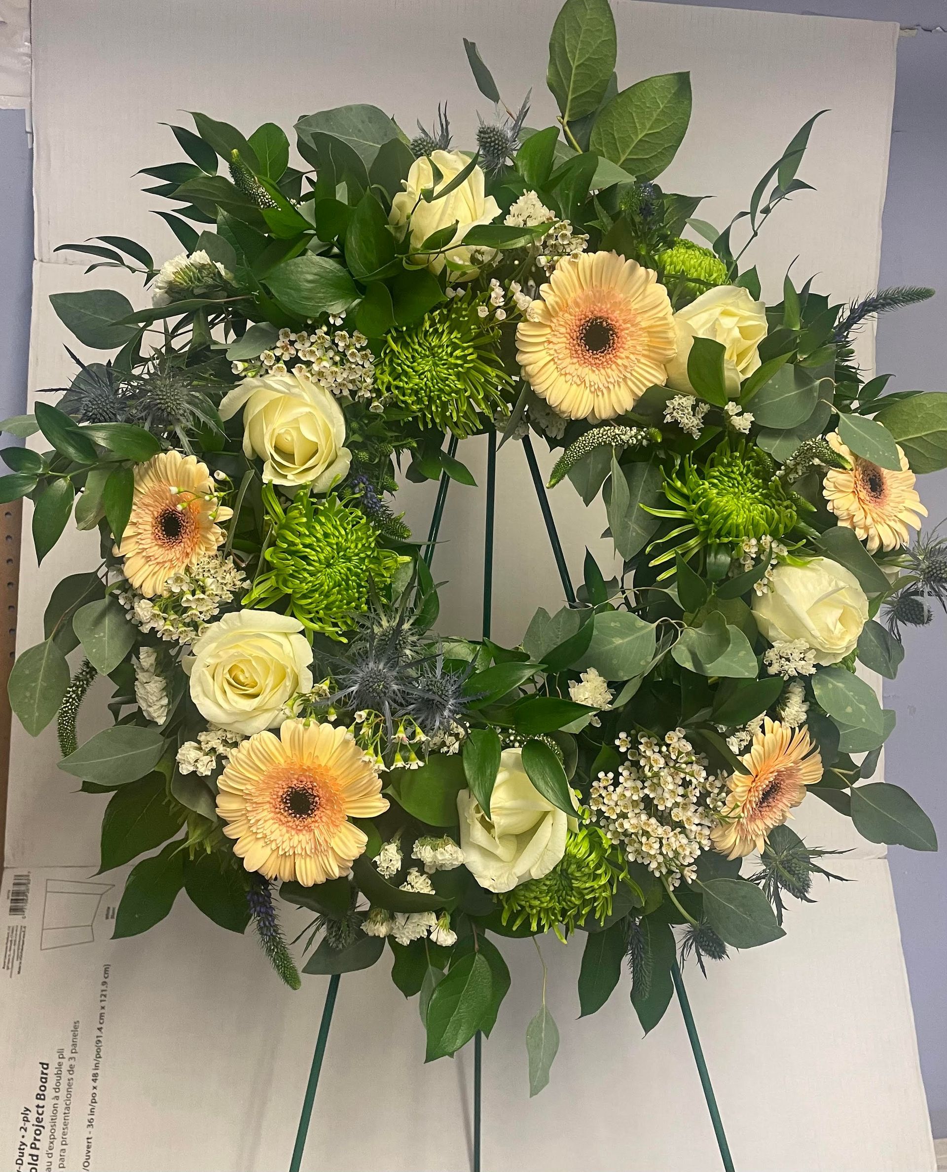 a wreath of flowers is sitting on top of a piece of paper