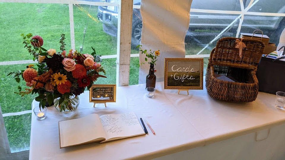 a table with a vase of flowers and a sign that says cards and gifts