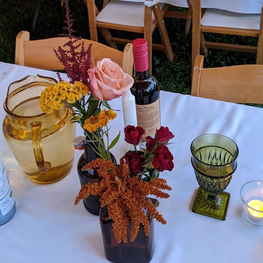 a table with flowers and a bottle of wine