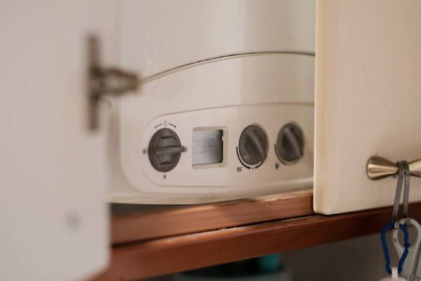 A close up of a boiler in a cabinet with the door open.