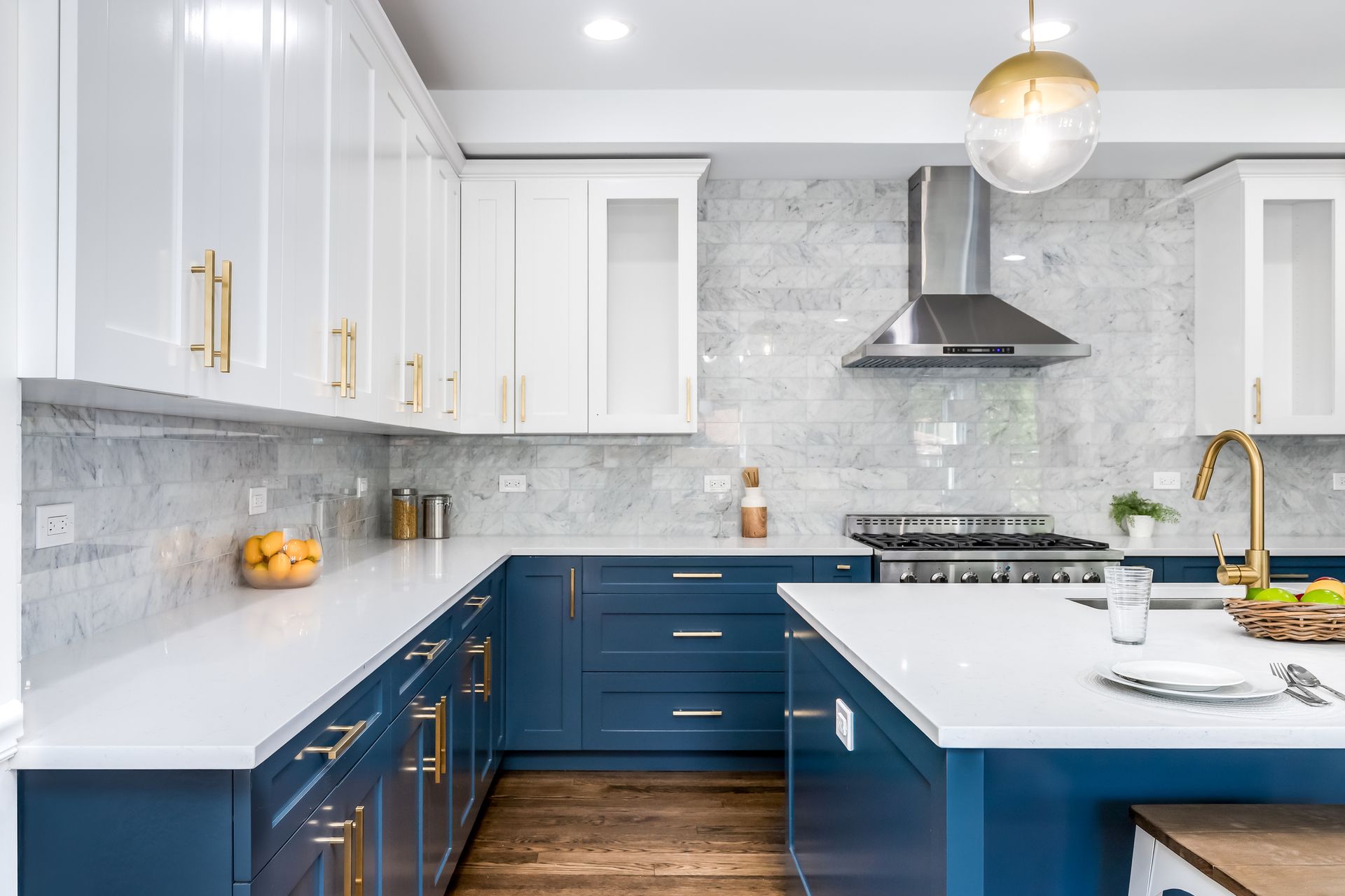 A kitchen with blue cabinets and white counter tops.