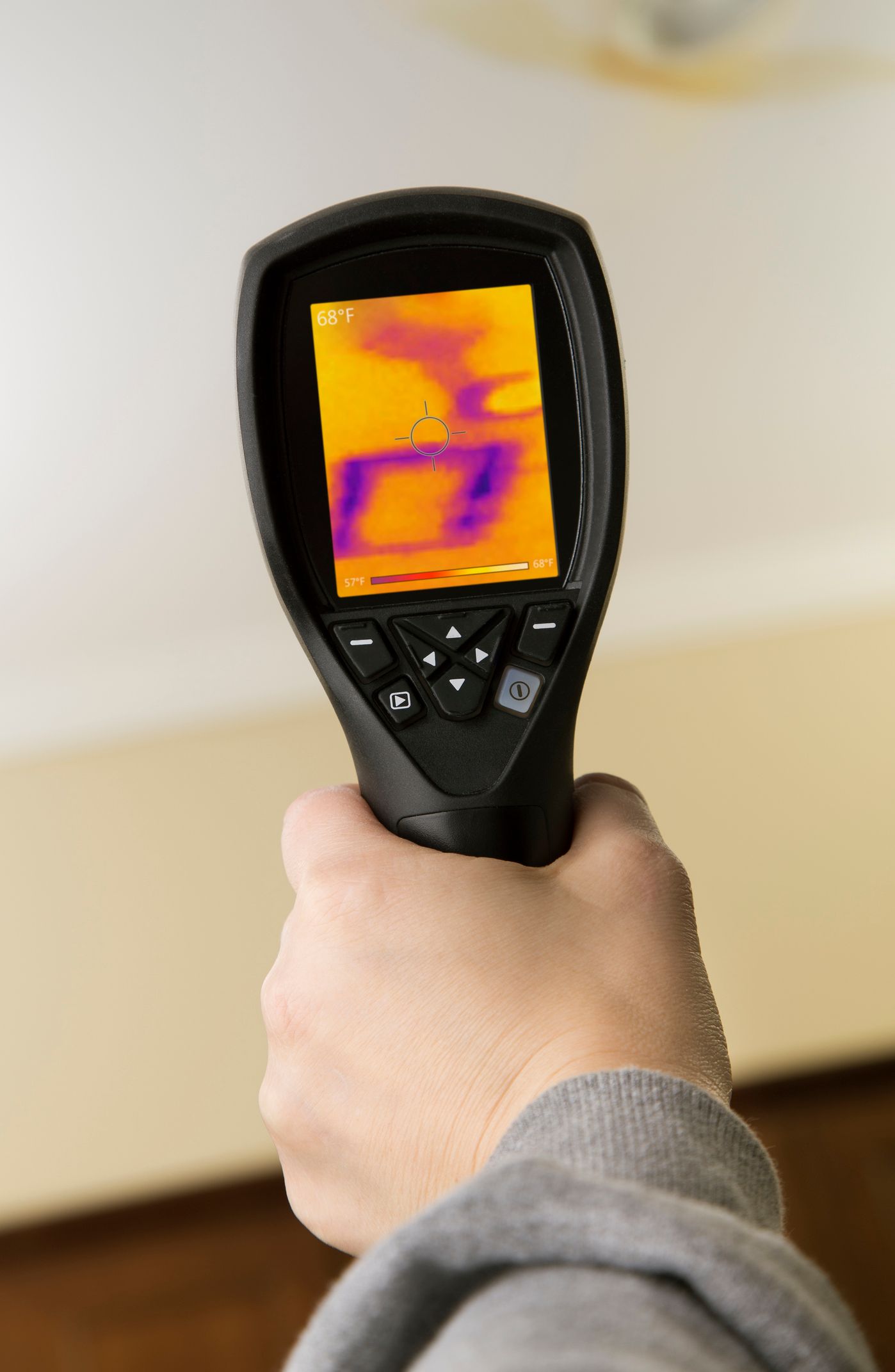 A person is holding a thermal camera in their hand.