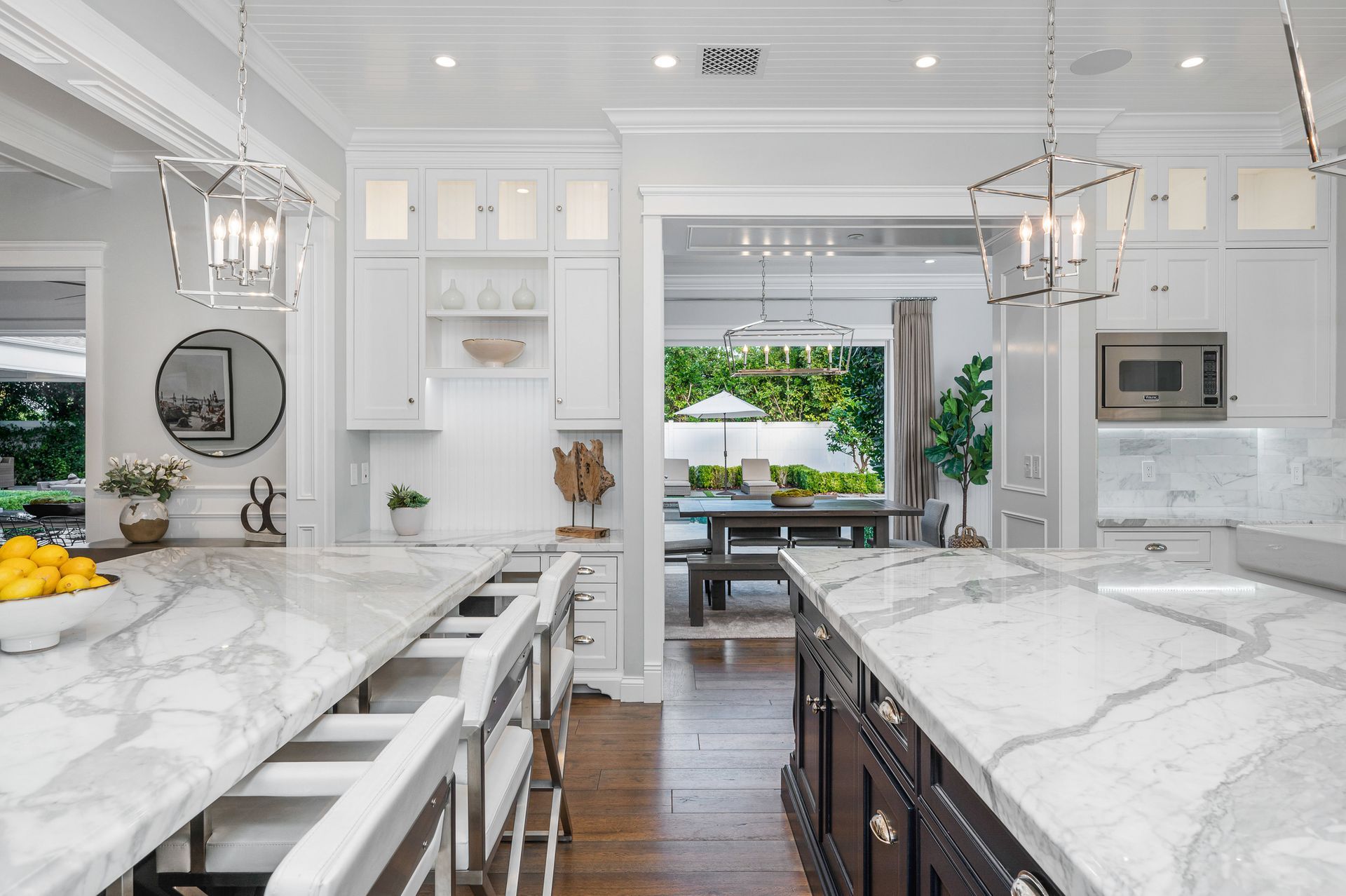 A kitchen with marble counter tops and white cabinets