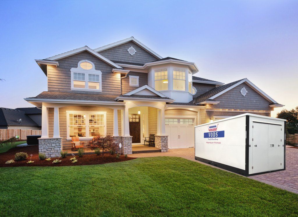 Suburban house at dusk with a large white generator on the lawn.