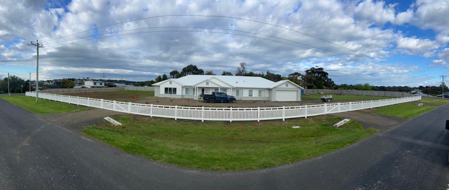 A large white tent is sitting in the middle of a grassy field next to a white fence.  — Talking Fences In Portarlington, VIC
