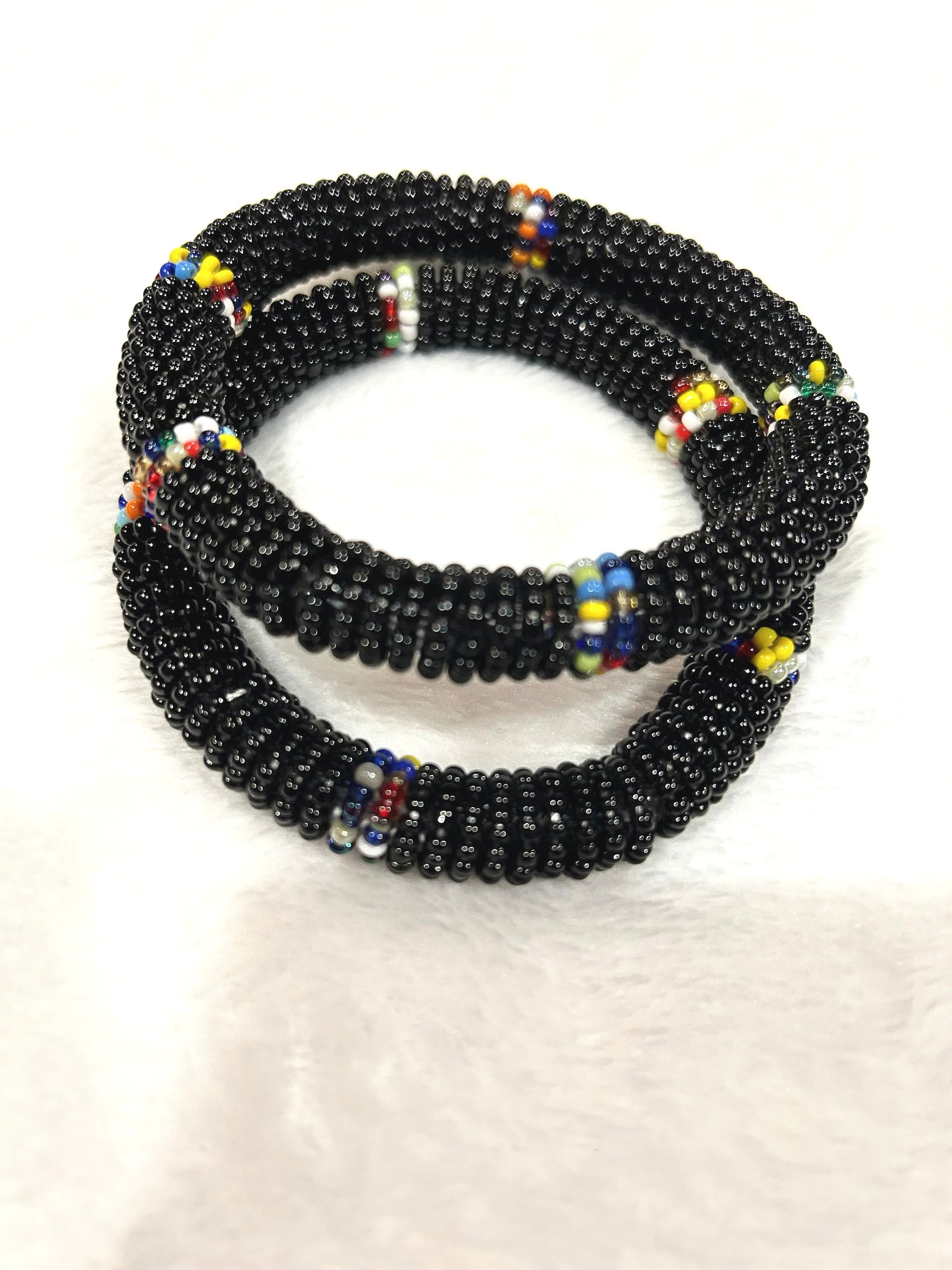 Two black beaded bracelets with colorful accents.