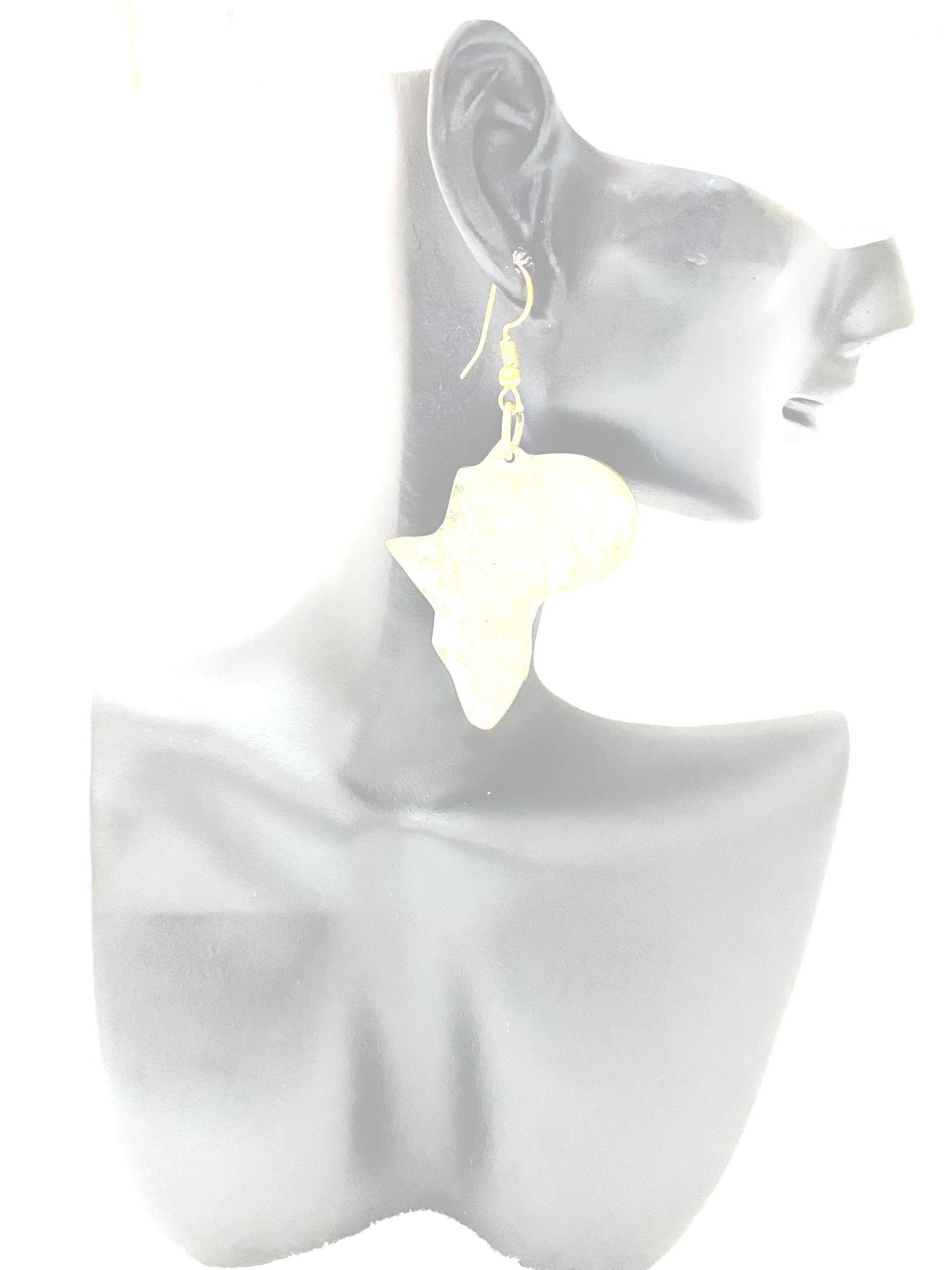 Earring shaped like the African continent, gold hook, dangling from a mannequin's ear.