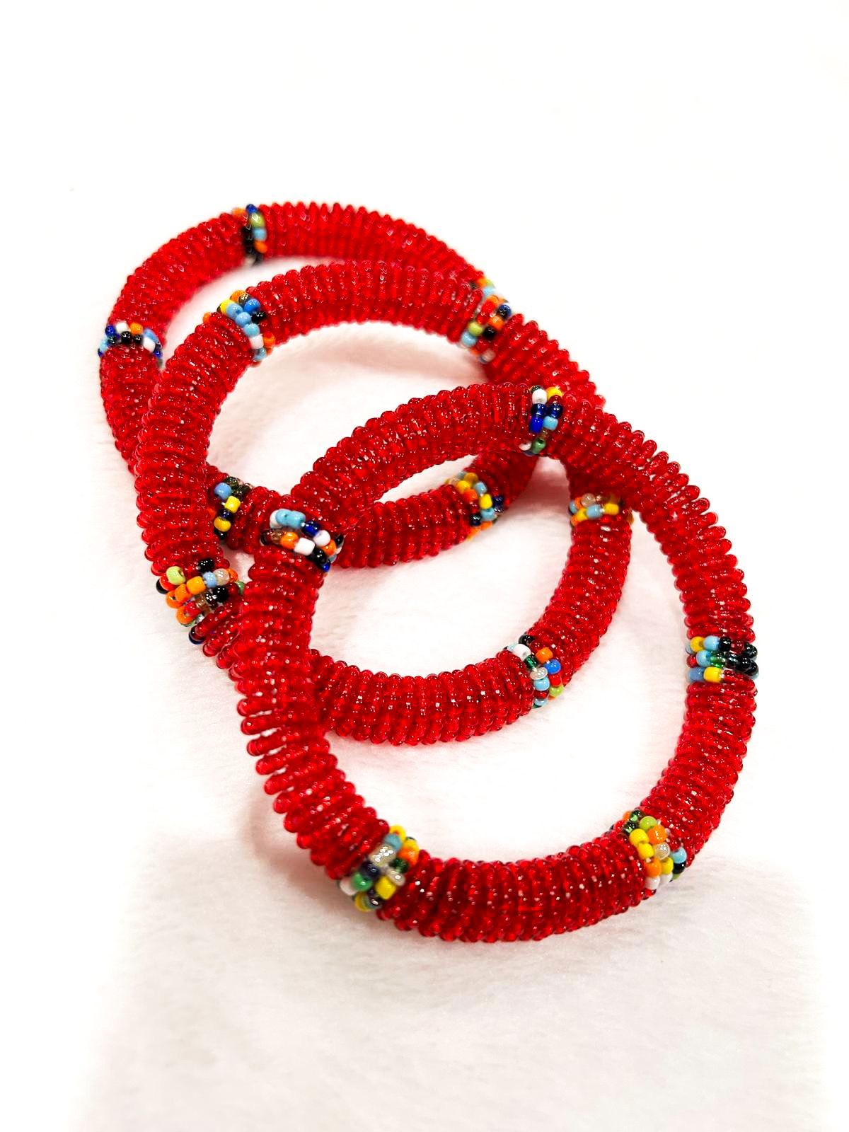Three red beaded bracelets intertwined, with colorful accents.