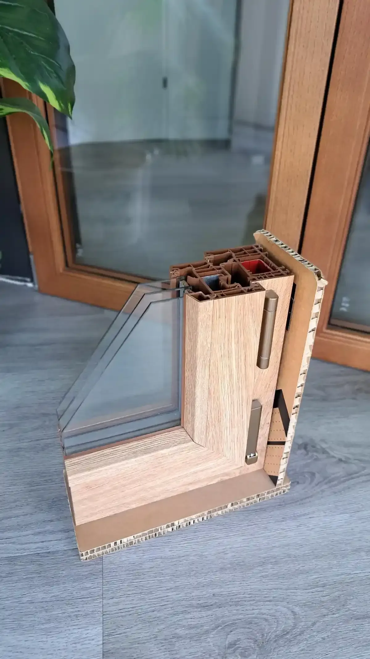 Campione angolare di cartone ondulato piegato accanto a una porta a vetri con cornice in legno.