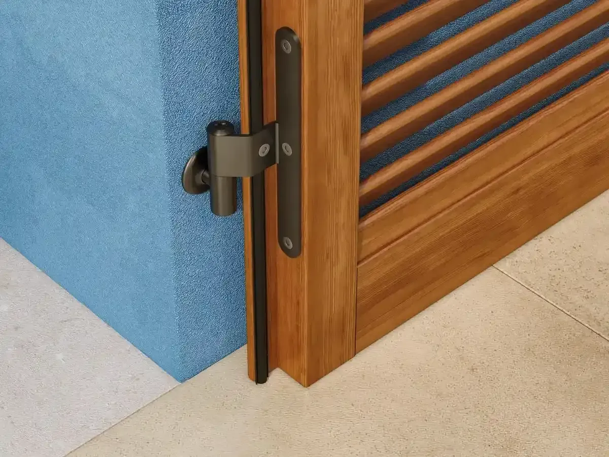 Cerniera per cancello a doghe di legno accanto a una parete blu e pavimento beige