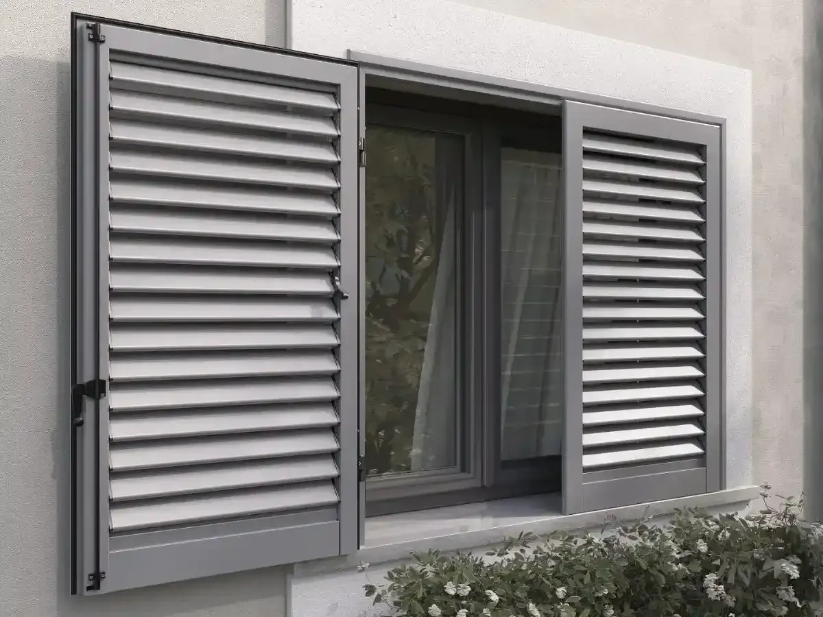 Finestra aperta con persiane metalliche grigie su una parete esterna beige