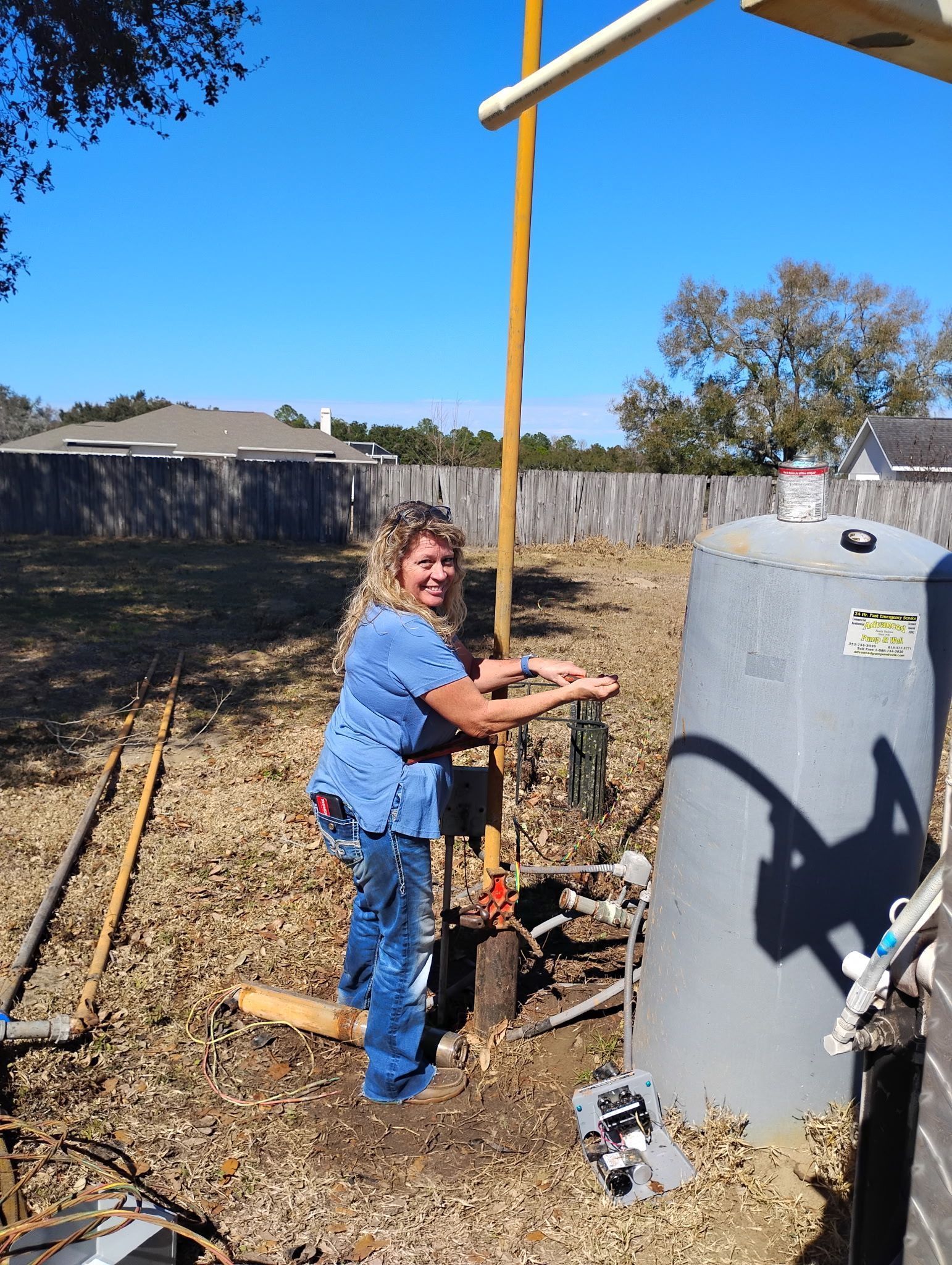 Andrea adjusting a well pressure tank setup on-site.