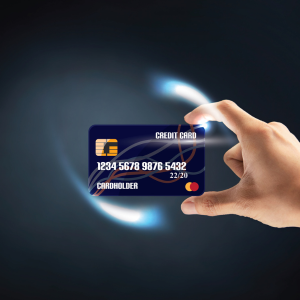 A hand is holding a credit card that says 1234 5678 9876 5432