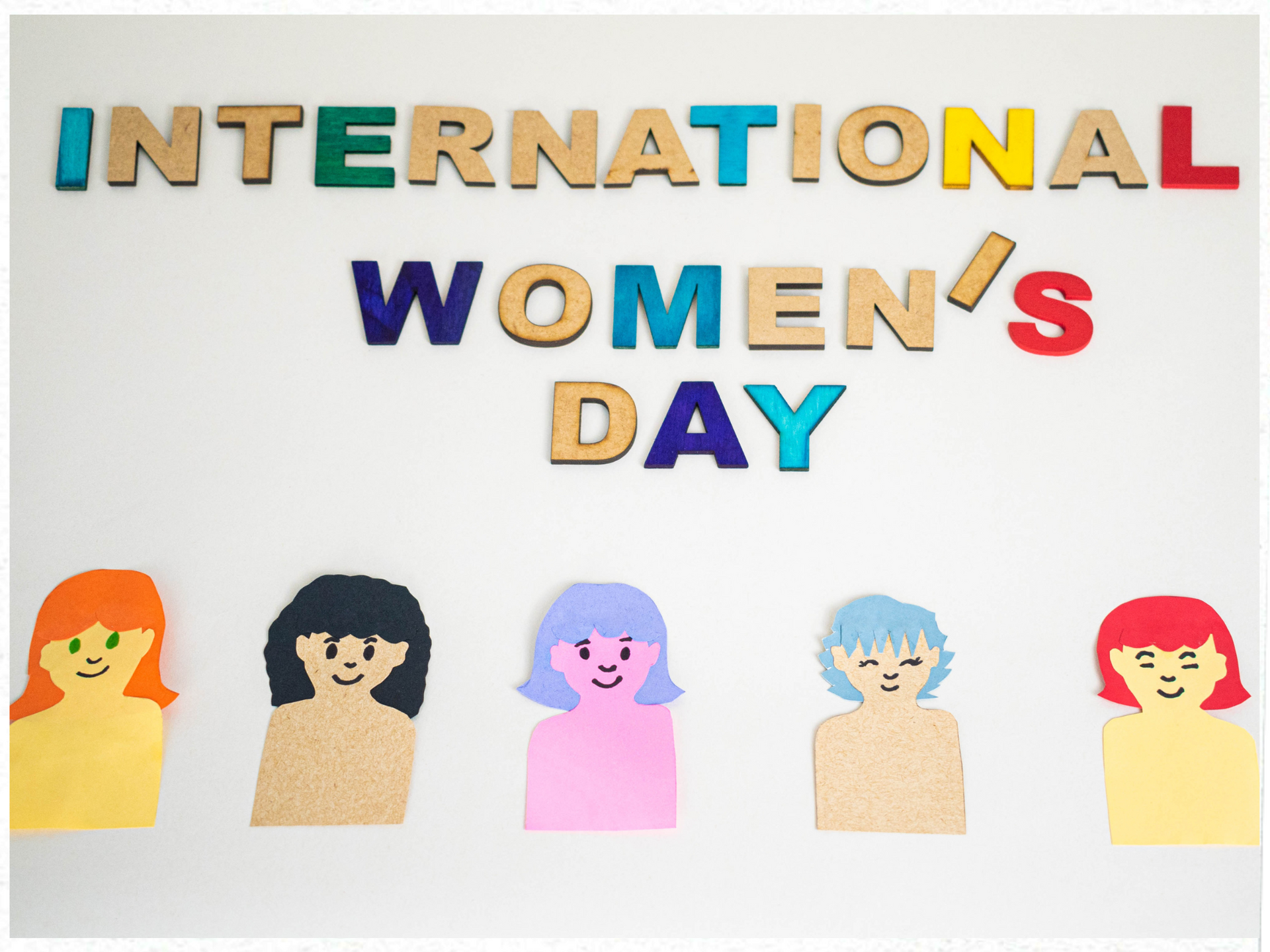 A sign for international women 's day with paper dolls