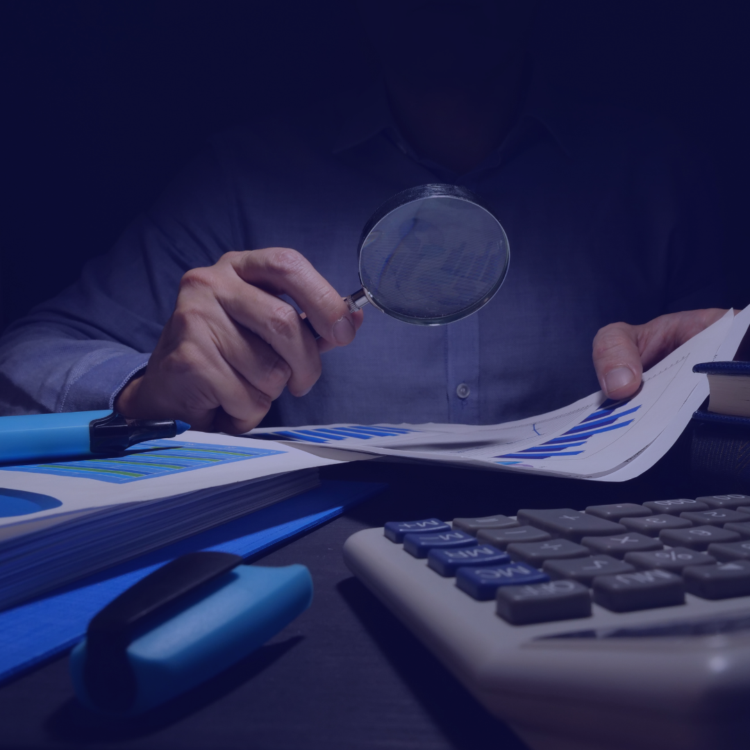A man is holding a magnifying glass over a piece of paper
