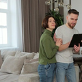Three people looking at a tablet in a bright living room