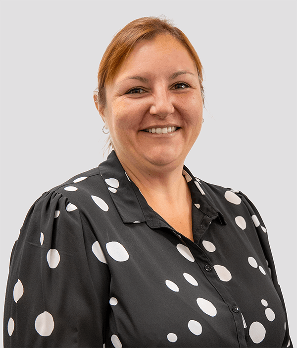 The woman is wearing a black jacket and smiling for the camera.