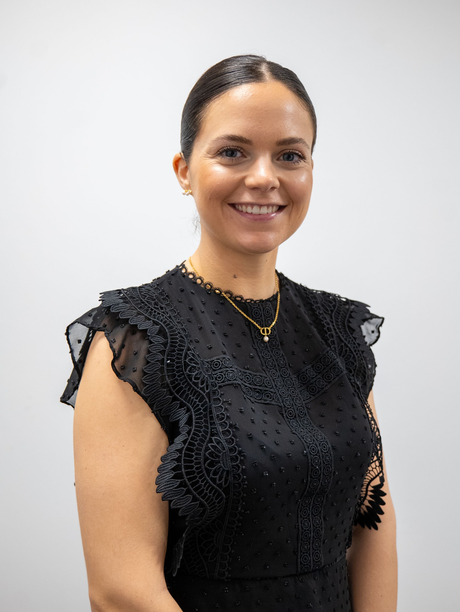 The woman is wearing a black jacket and smiling for the camera.