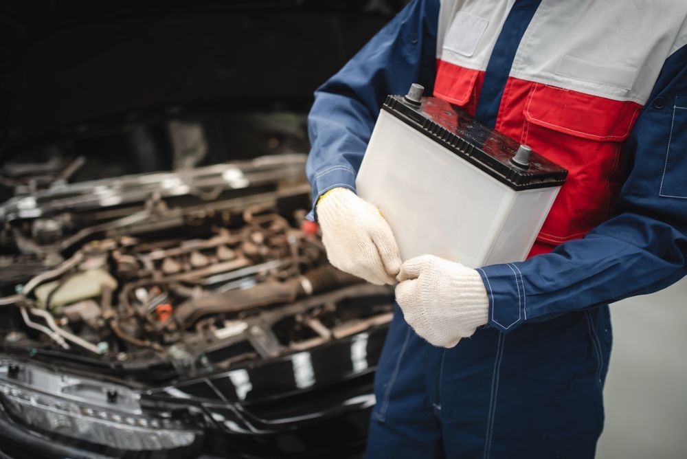 Mechanic in Blue Coveralls and Gloves Inspecting a Car Engine — Edmonton Battery Centre in Bentley Park, QLD