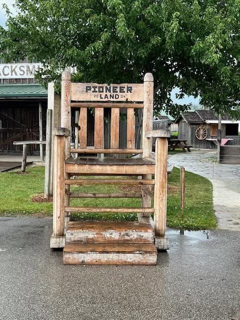 A large, rustic wooden chair labeled