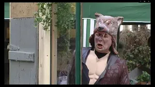 Ein Mann in einem Wolfskostüm steht vor einem Fenster.
