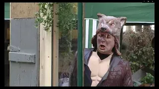 Ein Mann in einem Wolfskostüm steht vor einem Fenster.