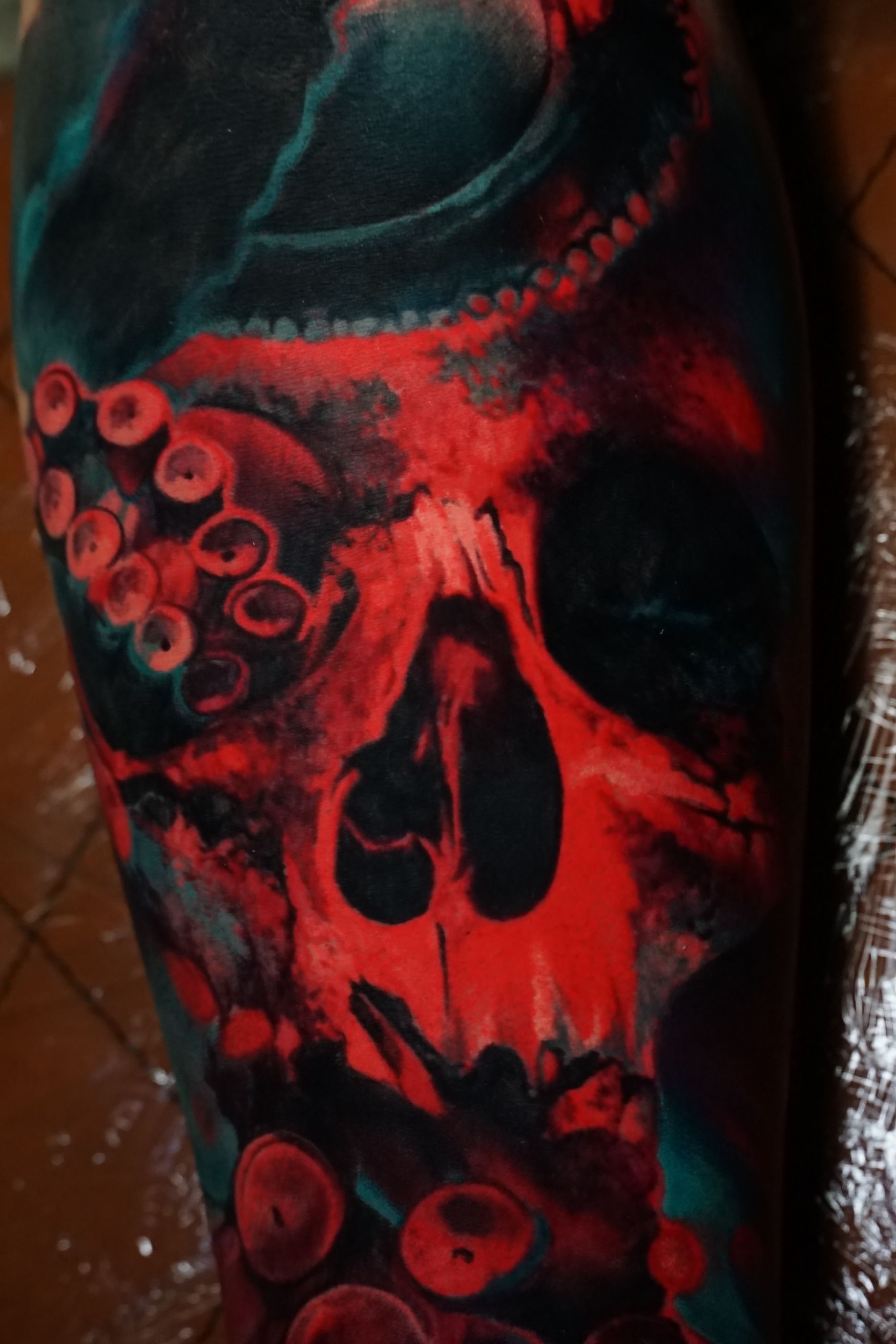 A tattoo of an octopus and a skull on a person 's arm