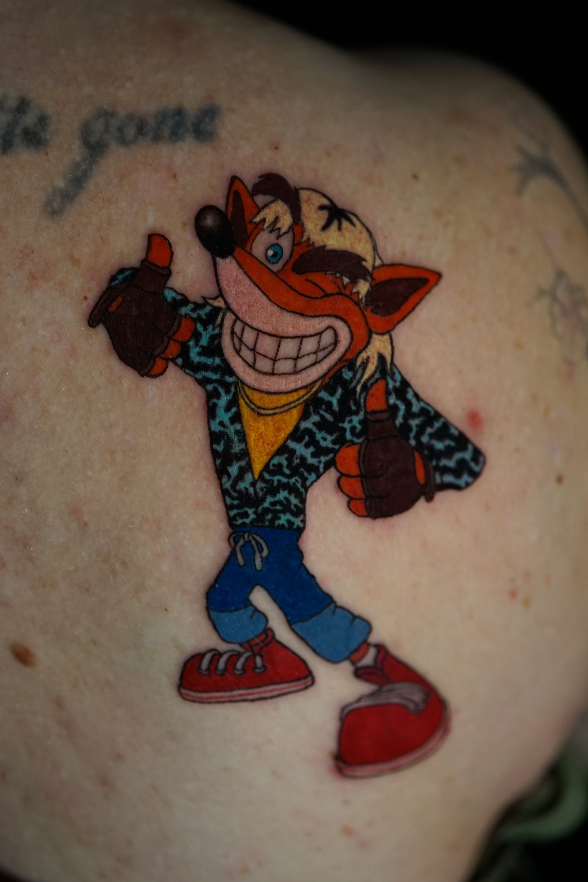 A tattoo of a cartoon character giving a thumbs up
