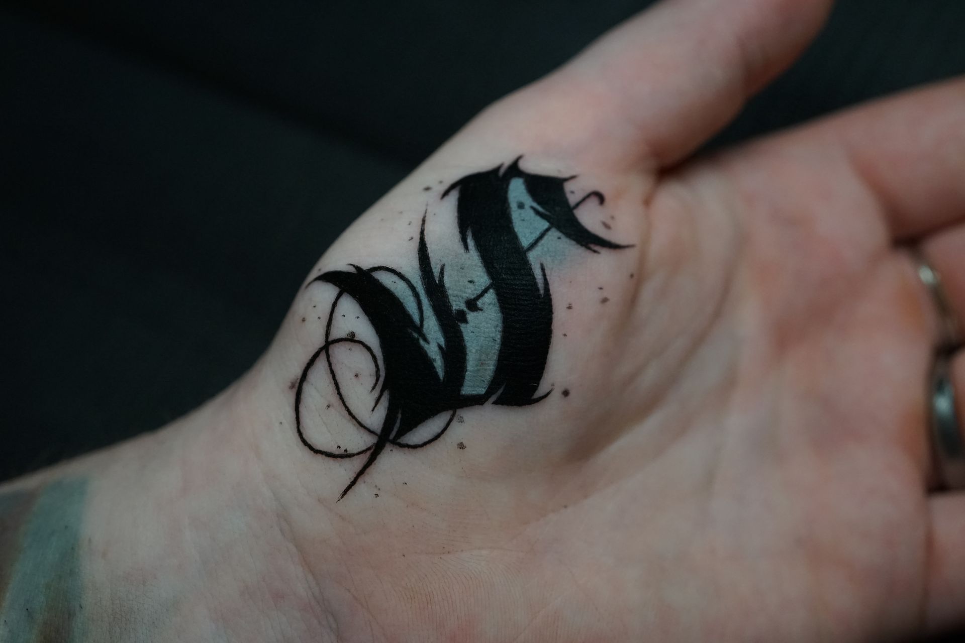 A close up of a person 's hand with a tattoo on it