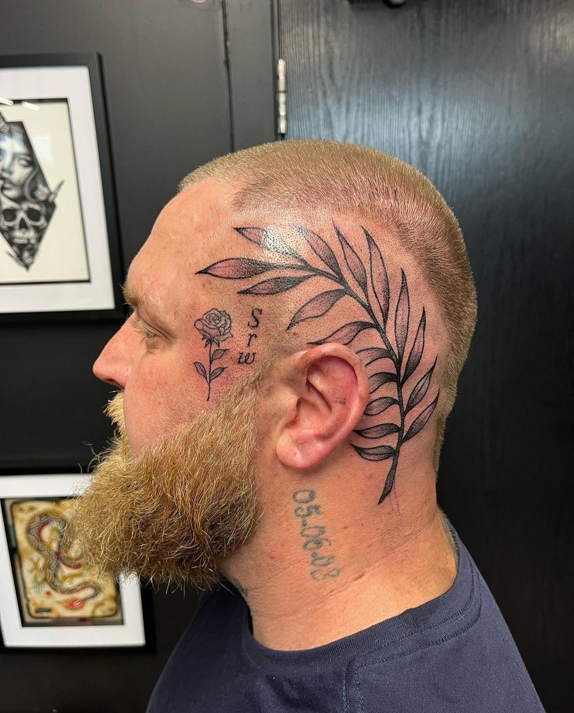 A man with a beard has a tattoo on his head and neck.