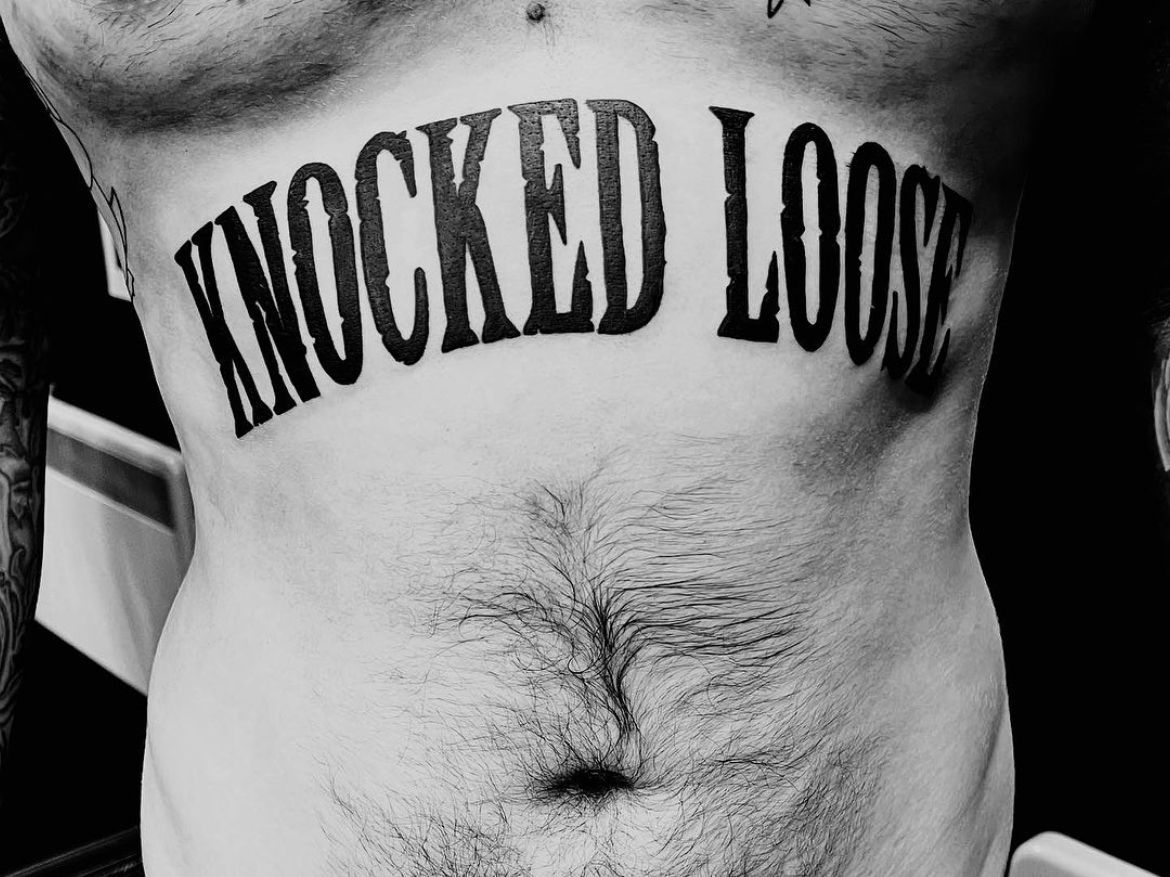 A man has a tattoo on his chest that says knocked loose
